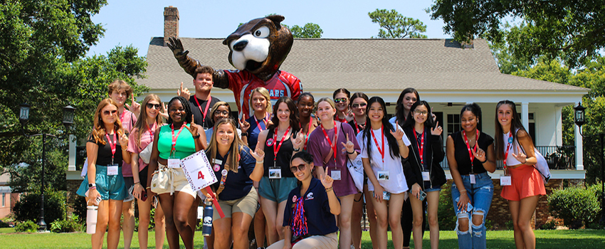 Orientation leaders with students in front of Southpaw statue.